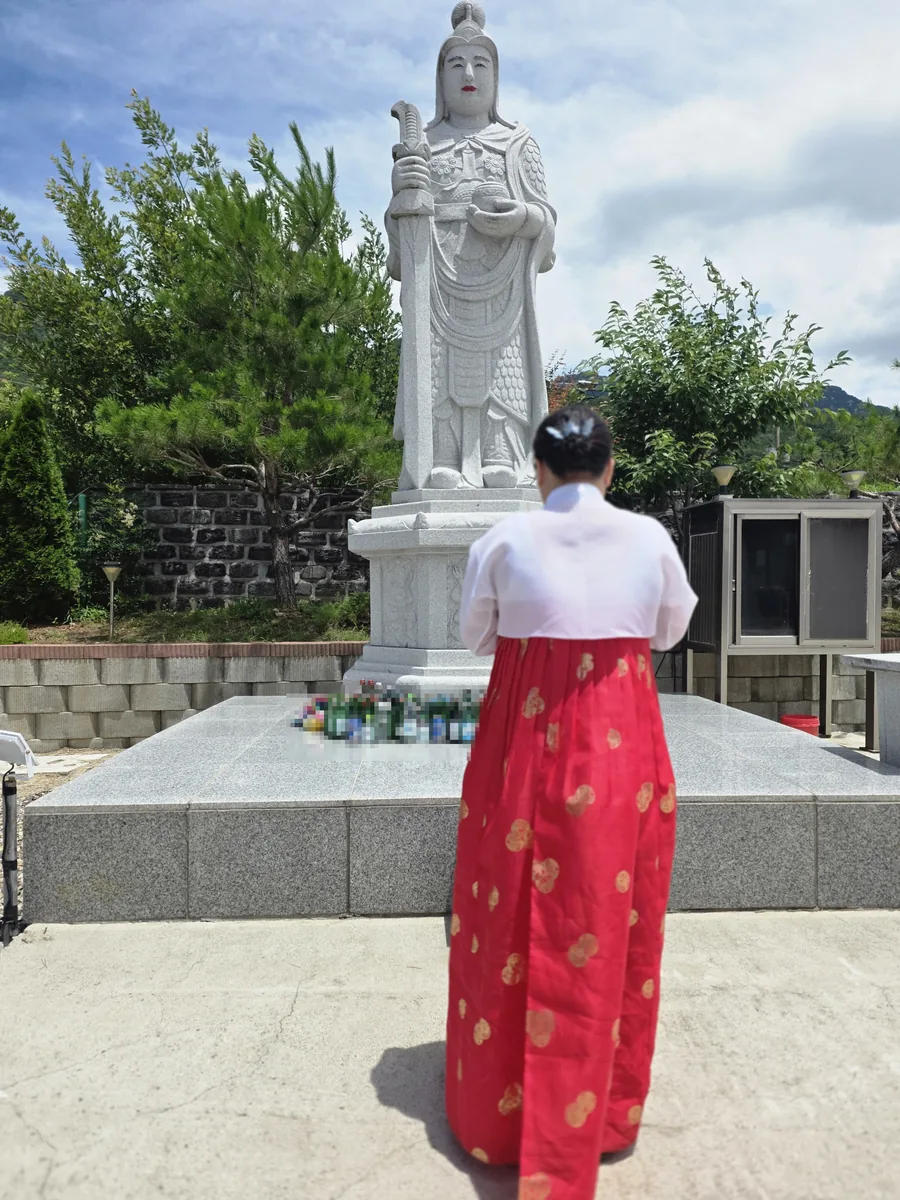 ▲사진=석상 앞에서 예를 올리는 모습.