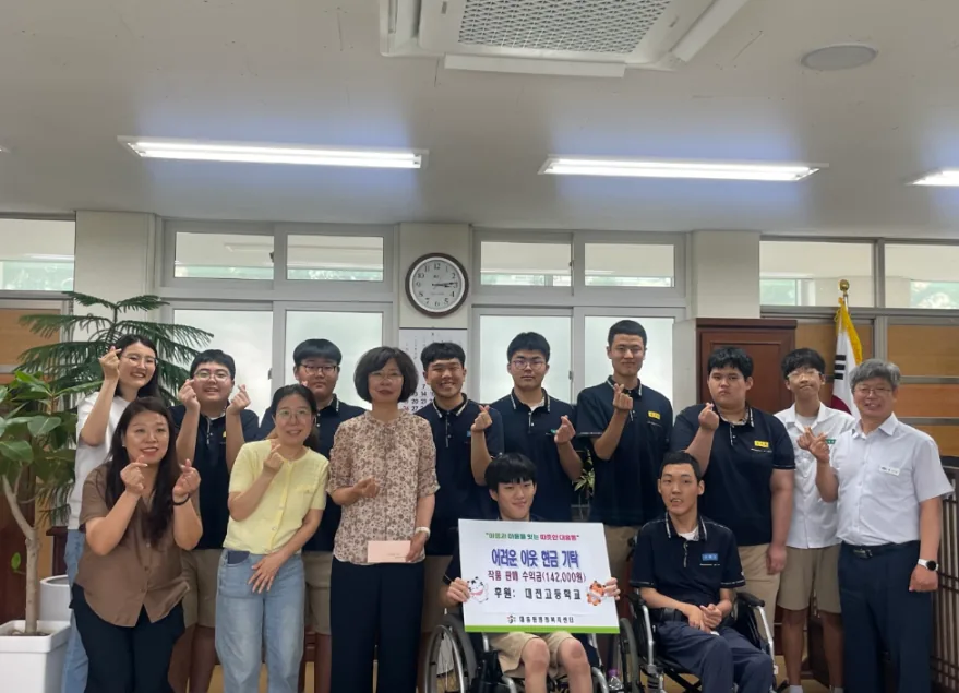 ▲사진설명=대전고등학교 특수학급 학생들이 작품 판매 수익금을 대흥동에 기탁한 뒤 관계자들과 기념촬영을 하고 있다.